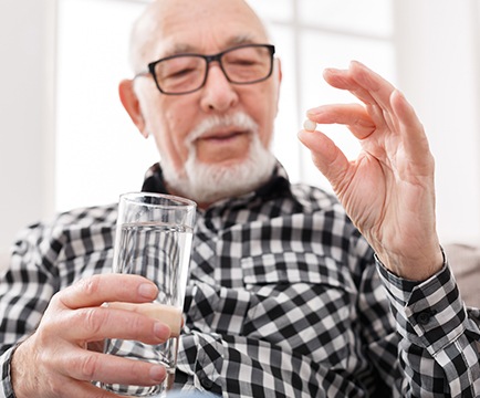 Older man holding an oral conscious dental sedation pill