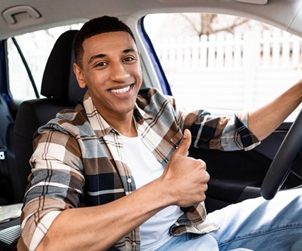 Man smiles in car