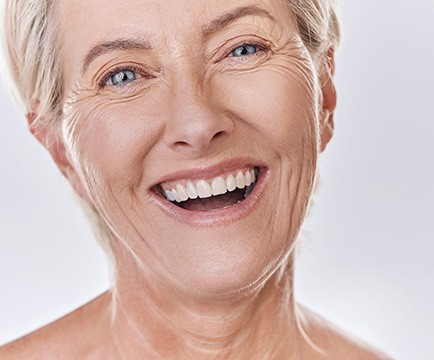 Woman smiling after learning how dentures are made in Baltimore