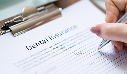 Female dental patient smiling and giving thumbs up